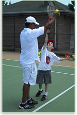 Steve
                Jackson teaching a student how to serve